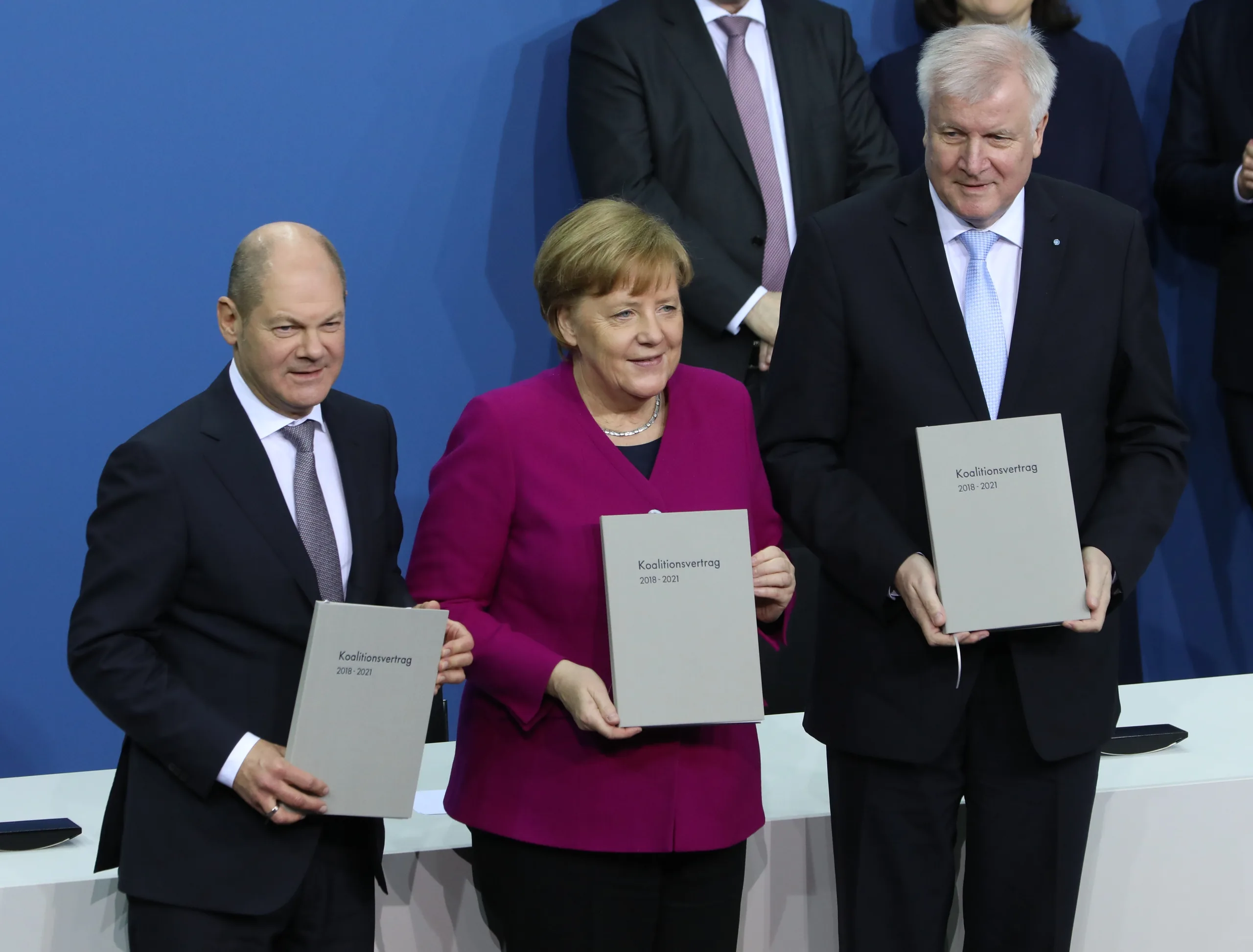 Olaf Scholz, Angela Merkel und Horst Seehofer mit dem unterzeichneten Koalitionsvertrag am 12. März 2018