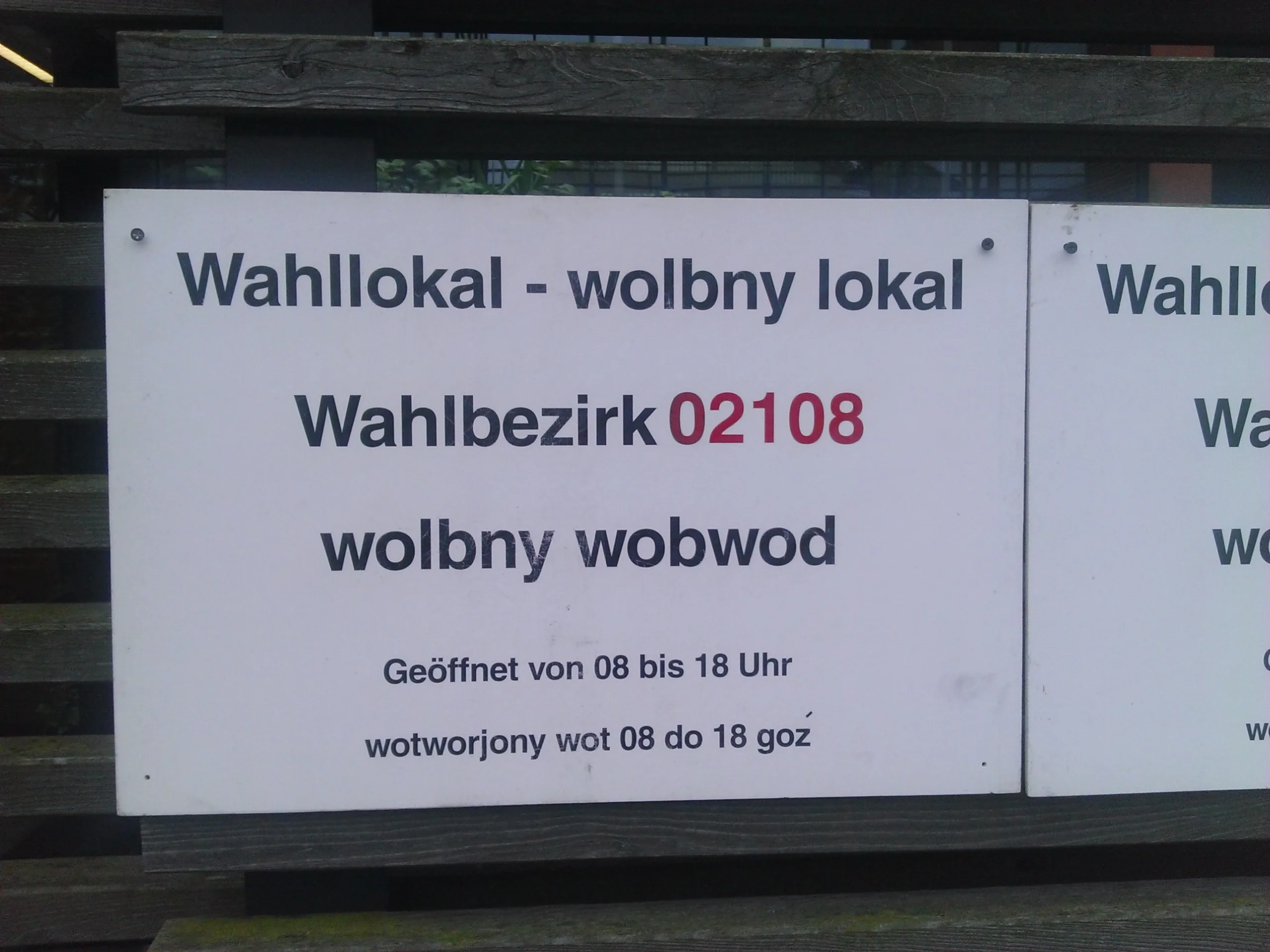 Zweisprachiges Schild „Wahllokal – wolbny lokal“ an einem Wahllokal in Cottbus